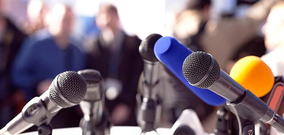 Mehrere Mikrofone während einer Pressekonferenz